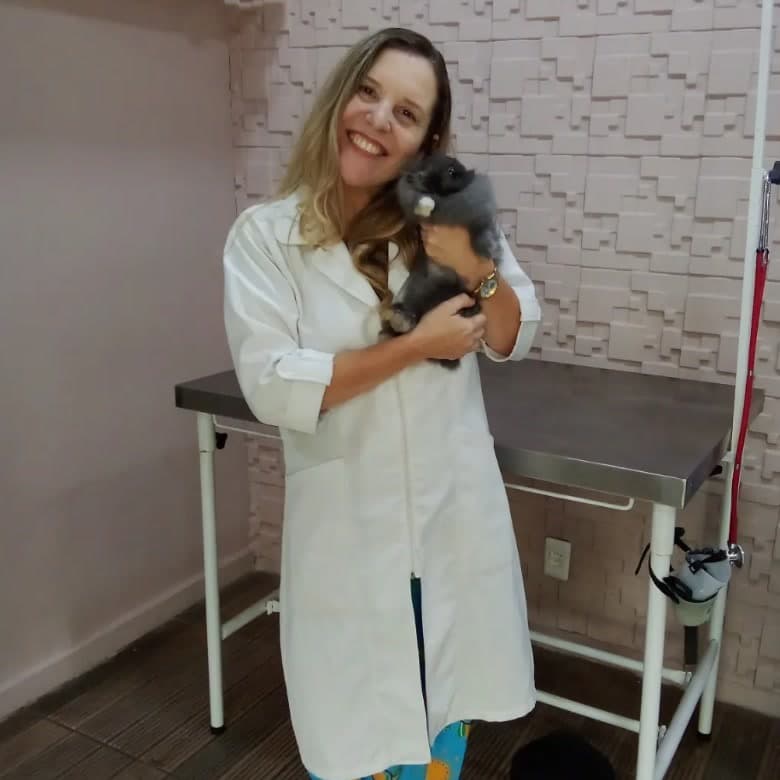 Dra. Ana Paula Ayres Pedro com um coelho no colo, na sala de atendimento